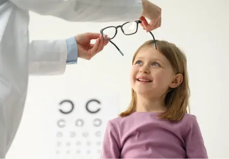 Young girl receiving a pediatric eye exam in a child-friendly eye clinic in Calma, Algeria with diagnostic tools